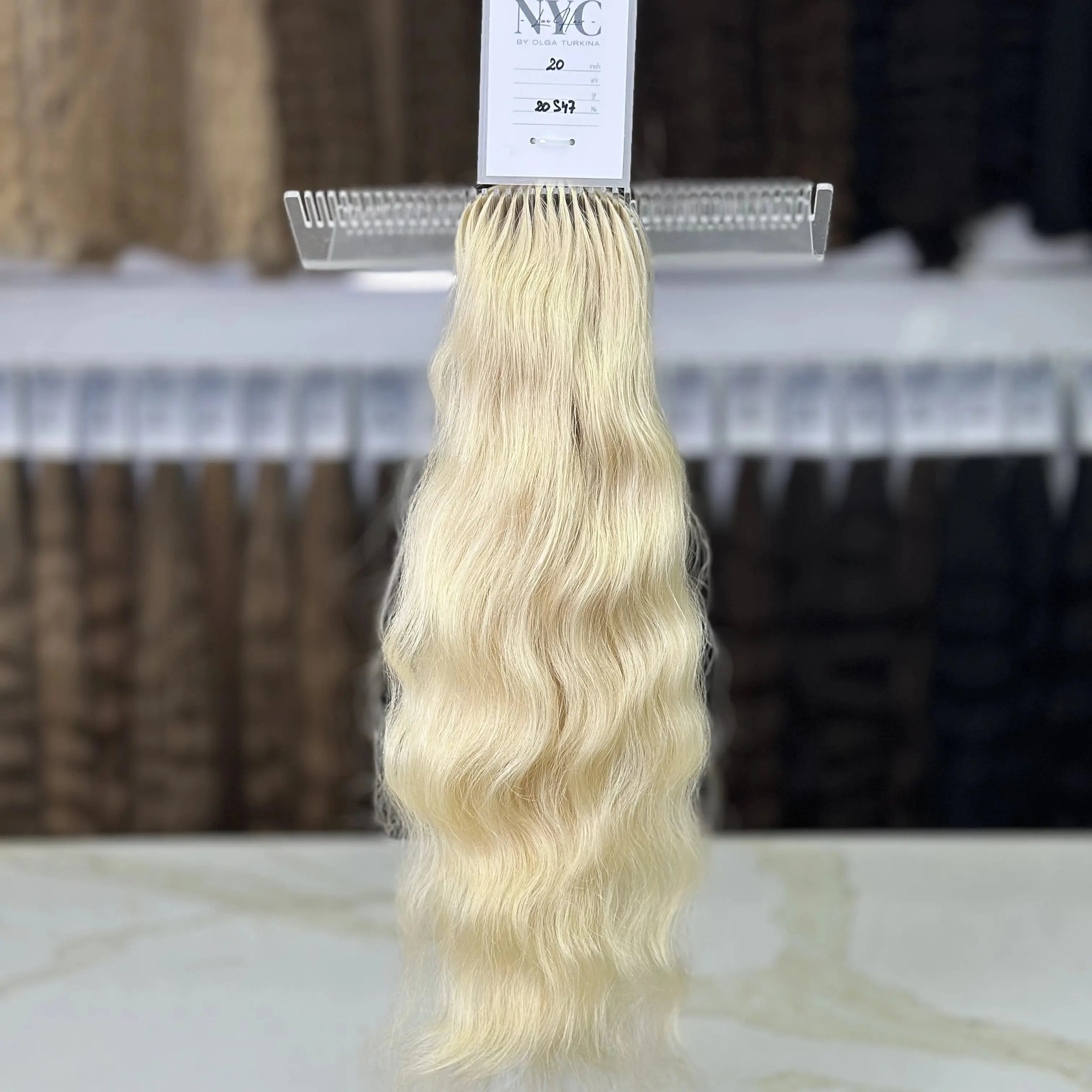 Blonde hair extensions on a display stand with a 'NYC' label.