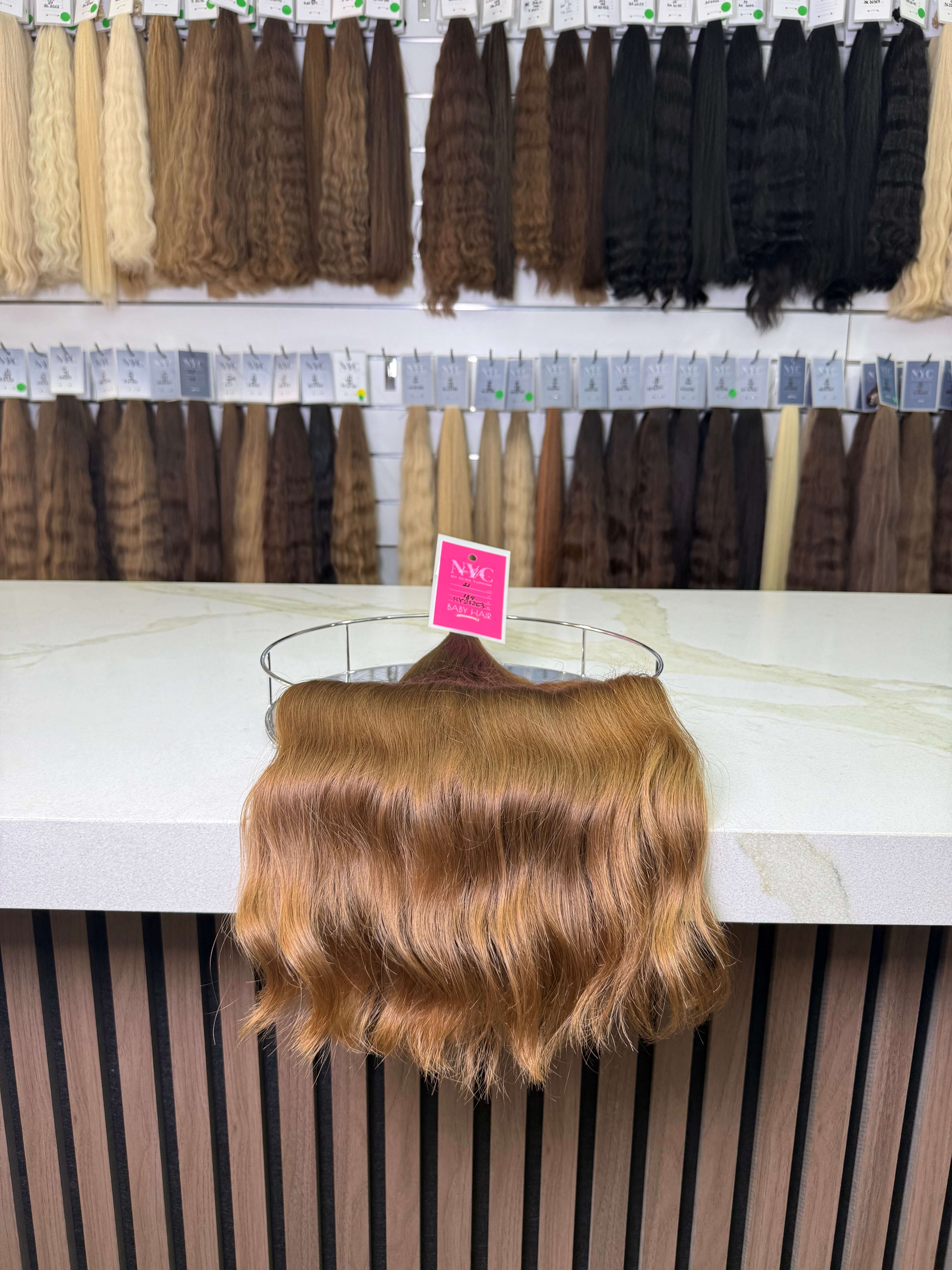 Display of hair extensions, with a brown piece in the foreground.