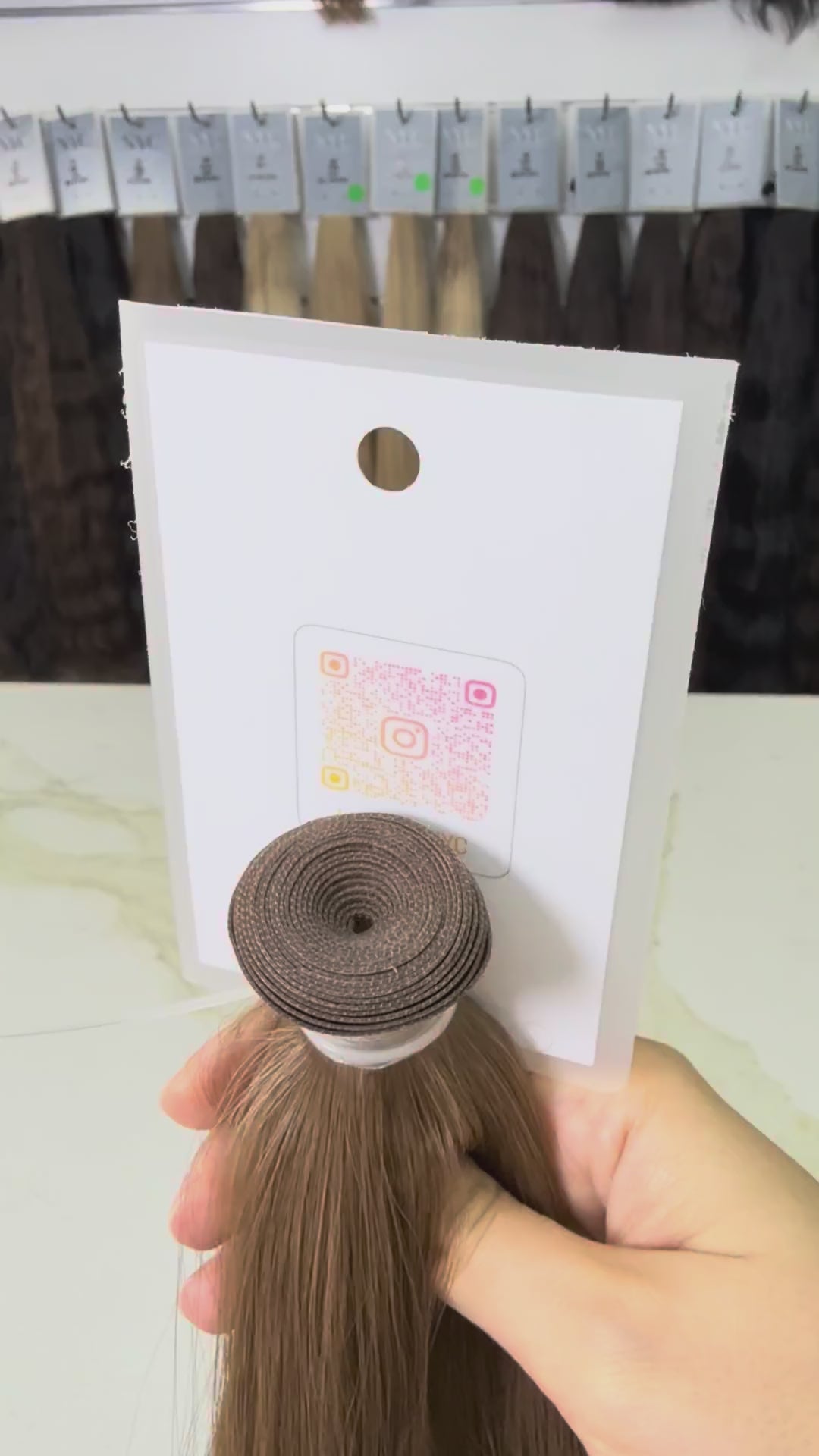 Premium Russian Slavic Weft, Brown hair extension on a stand  against a blurred background.