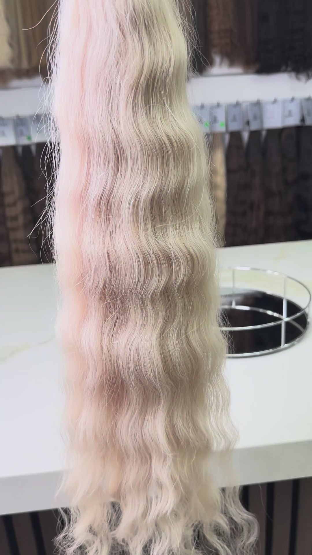 Blonde hair extensions on a stand with a blurred background