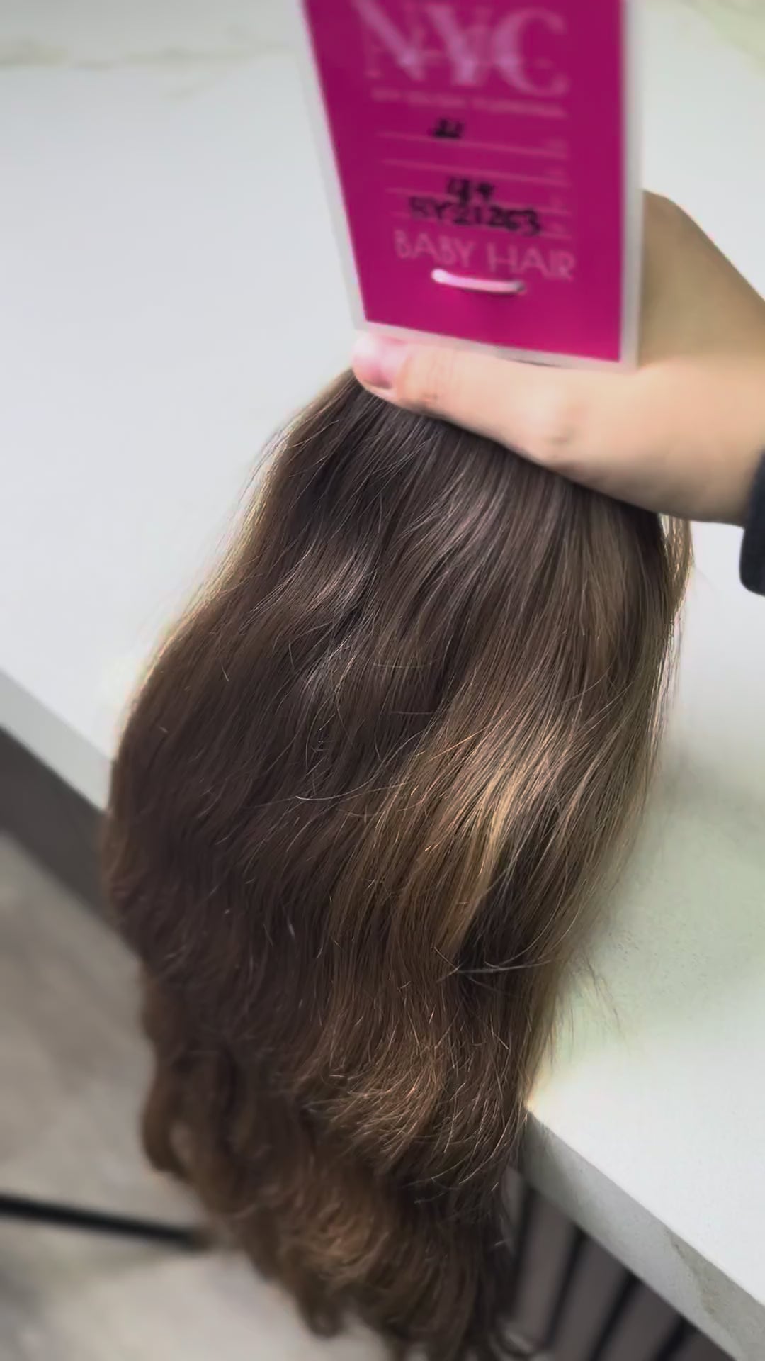 Brown hair extensions on a stand with a blurred background
