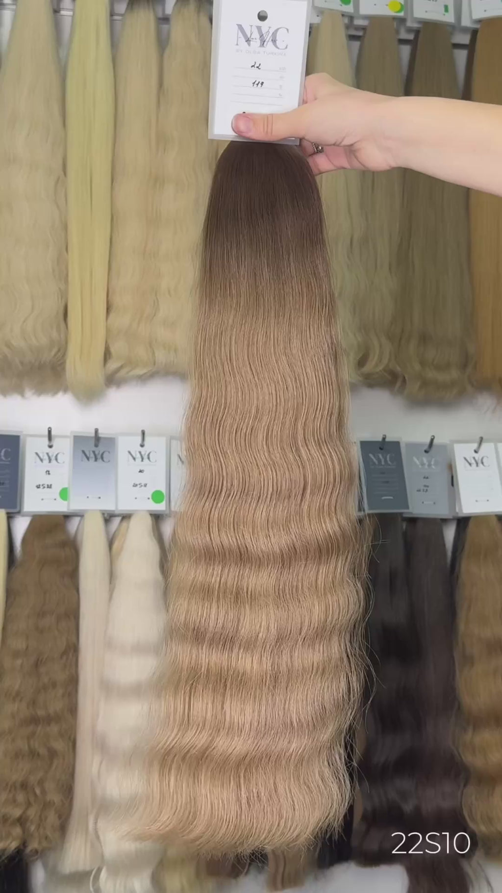 Brown hair extensions on a white surface with a blurred background